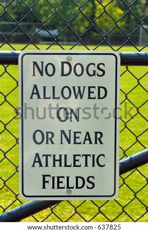 No Dogs allowed sign on a chain linked fence