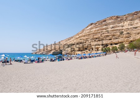 CRETE,GREECE-JULY 22: Tourists on Matala beach with the caves on July 22,2014 Crete, Greece.