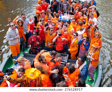 AMSTERDAM,NETHERLANDS-APRIL 27: Locals dressed in orange celebrate King\'s Day on a boat on April 27,2015 in Amsterdam.  King\'s Day is the largest open-air festivity in Amsterdam.