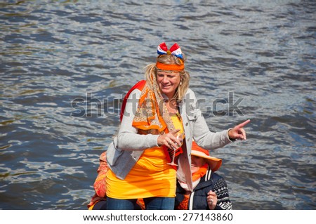 AMSTERDAM-APRIL 27: Active participant on boat party during King\'s Day on April 27,2015 in Amsterdam, the Netherlands. Kings Day is the biggest festival celebrating the birth of Dutch royalty.