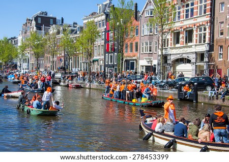AMSTERDAM-APRIL 27: Party Boat with crowd of people along the canal on King\'s Day on April 27,2015, the Netherlands. King\'s Day is the largest open-air festivity in Amsterdam.