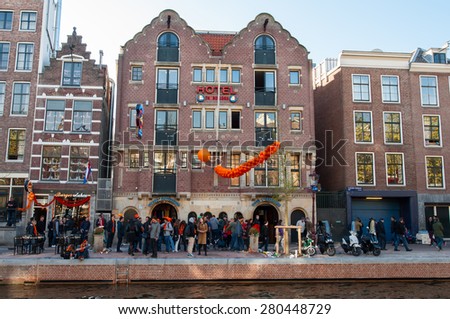 AMSTERDAM-APRIL 27: Famous Amsterdam Bulldog coffeeshop and hotel in red-light district, people celebrate King's Day outside the cafe on April 27,2015, the Netherlands.