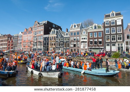 AMSTERDAM-APRIL 27: Crowd of people on the boats participate in celebrating King\'s Day on April 27,2015 the Netherlands. King\'s Day is the largest open-air festivity in Amsterdam.