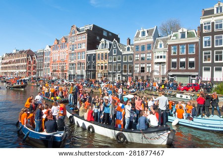 AMSTERDAM-APRIL 27: Crowd of people on boats take part in celebrating King\'s Day on April 27,2015 the Netherlands. King\'s Day is the largest open-air festivity in Amsterdam.