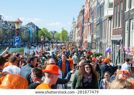 AMSTERDAM-APRIL 27: Locals and tourists celebrate King\'s Day along the Singel canal on April 27,2015, the Netherlands. King\'s Day is the largest open-air festivity in Amsterdam.
