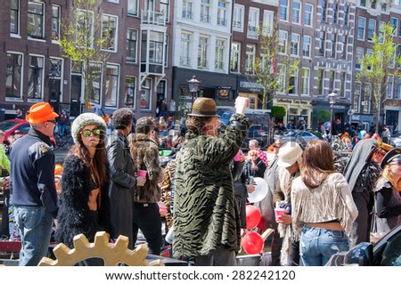 AMSTERDAM-APRIL 27: Unidentified people at the open-air party during King\'s Day on the Singel canal on April 27,2015, the Netherlands. King\'s Day is the largest open-air festivity in Amsterdam.
