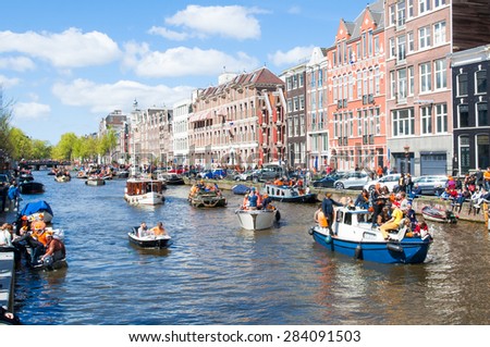 AMSTERDAM-APRIL 27: Celebrating  King's Day along the Singel canal on April 27,2015. King's Day is the biggest festival celebrating the birth of Dutch royalty.