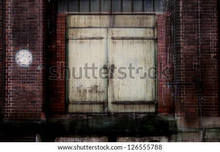 The photograph of an old steel door on a closed industrial area/Old steel door