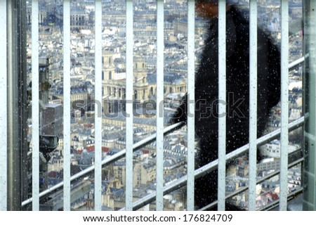 The photograph of the silhouette of a man going down a staircase behind a lattice / Behind Bars