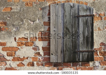 The close up of a wooden hatch in the brick wall of a barn / Wooden hatch