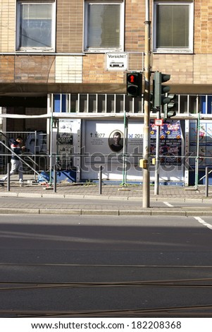 FRANKFURT, GERMANY - FEBRUARY 19: A pedestrian passes a traffic light at a construction site with posters on February 19, 2014 in Frankfurt