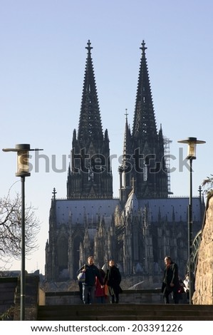 COLOGNE, GERMANY - FEBRUARY 2: Walkers go down the stairs of the Hohenzollern Bridge on February 02, 2014 in Cologne with the Cologne Cathedral in the background / Cologne cathedral