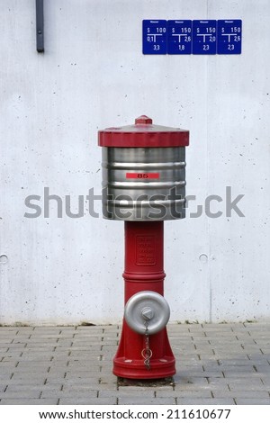 The closeup of a fire hydrant in front of a concrete wall with signs / Fire hydrant