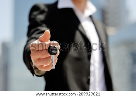 caucasian businessman holding a car key in his hand - new car buy sale concept
