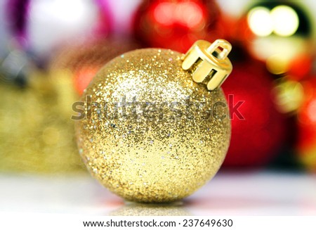 Christmas decorations. Yellow ball on blurred multicolored abstract background