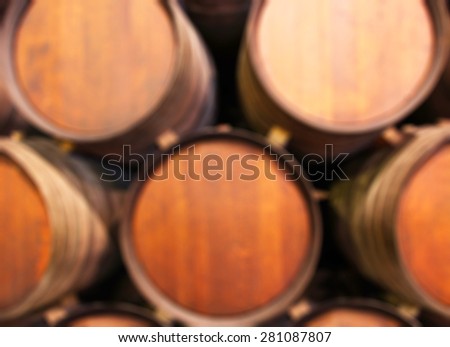 Blurred background : Row of wooden barrels of tawny portwine ( port wine ) in cellar, Porto, Portugal. vintage business and travel concept