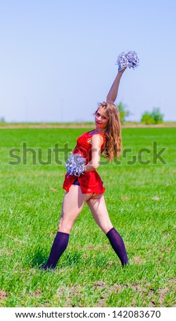Cheerleader poses on the grass