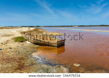 Abandoned boat on the shore of the pink lake called Lake Retba or Lac Rose, Senegal