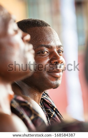 GHANA - MARCH 3, 2012: Unidentified Ghanaian man watches the girl dancing traditional African dance in Ghana, on March 3rd, 2012. Music is the main kind of entertainment in Africa