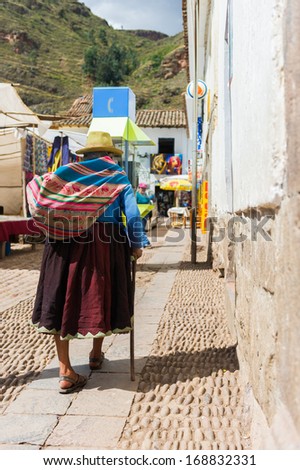 PERU - NOVEMBER 3, 2010: Unidentified Peruvian lady in the popular bowler hat walks the street in Peru, Nov 3, 2010. Over 50 per cent of people in Peru live below the the poverty line.