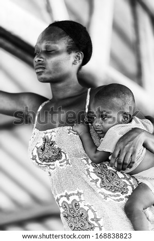 TOGO - MARCH 9, 2013: Unidentified Togolese woman holds her baby in her arms in Togo, Mar 9, 2013. People in Togo suffer from poverty due to the unstable economical situation.