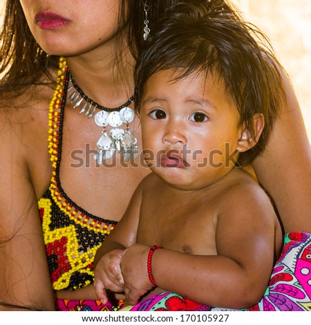 EMBERA VILLAGE, PANAMA, JANUARY 9, 2012: Unidentified native Indian woman holds her baby on her hands in Panama, Jan 9, 2012. Indian reservation is the way to conserve native culture