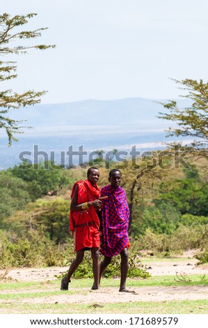 AMBOSELI, KENYA - OCTOBER 10, 2009: Two unidentified Massai people walk and talk in Kenya, Oct 10, 2009. Massai people are a Nilotic ethnic group