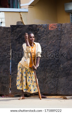 ANTANANARIVO, MADAGASCAR - JUNE 30, 2011: Unidentified Madagascar woman stays with a stick and stays in the street. People in Madagascar suffer of poverty due to slow development of the country