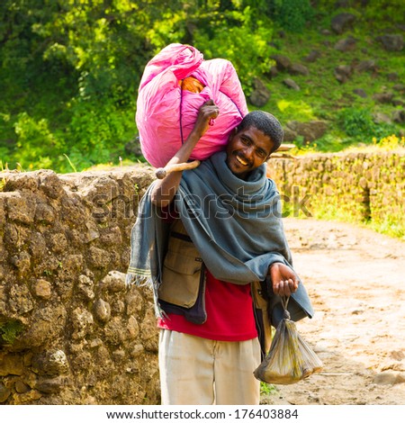 OMO, ETHIOPIA - SEPTEMBER 20, 2011: Unidentified Ethiopian man carries a pink bag. People in Ethiopia suffer of poverty due to the unstable situation