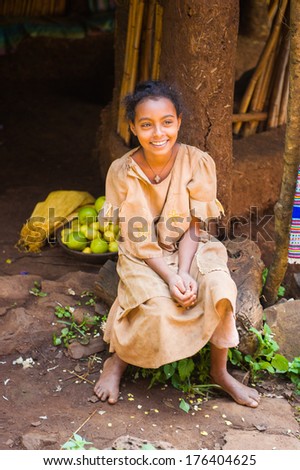 OMO, ETHIOPIA - SEPTEMBER 20, 2011: Unidentified Ethiopian beautiful girl smiles near a house porch. People in Ethiopia suffer of poverty due to the unstable situation