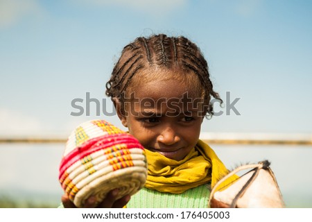 OMO, ETHIOPIA - SEPTEMBER 19, 2011: Unidentified Ethiopian shy beautiful girl sells tradtional souvenirs to tourists. People in Ethiopia suffer of poverty due to the unstable situation