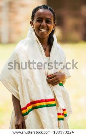 AKSUM, ETHIOPIA - SEPTEMBER 24, 2011: Unidentified Ethiopian girl smiles in a white tissue with national colors of Ethiopia. People in Ethiopia suffer of poverty due to the unstable situation
