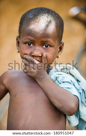 PORTO-NOVO, BENIN - MAR 8, 2012: Unidentified Beninese little boy shuts his mouth. People of Benin suffer of poverty due to the difficult economic situation.