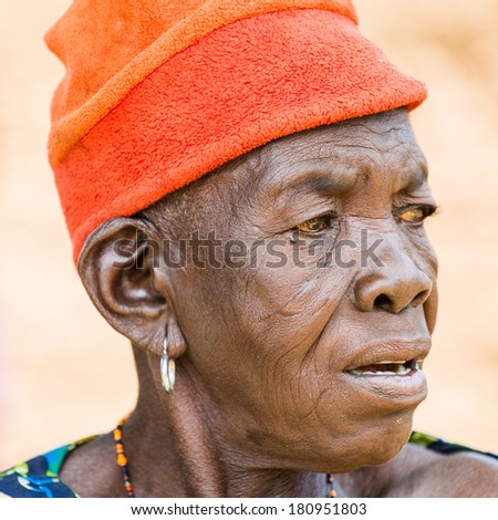 PORTO-NOVO, BENIN - MAR 8, 2012: Unidentified Beninese angry woman in a red hat. People of Benin suffer of poverty due to the difficult economic situation.