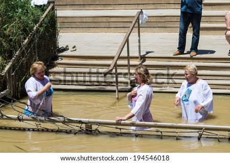JESUS CHRIST BAPTISM SITE , ISRAEL - MAY 1, 2014: Unidentified women in the Sacred water of the River Jordan. River where Jesus of Nazareth was baptized by John the Baptist.