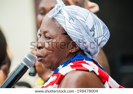 ACCRA, GHANA - MARCH 4, 2012: Unidentified Ghanaian woman sings a song for a local musical street show in Ghana. People of Ghana suffer of poverty due to the unstable economic situation