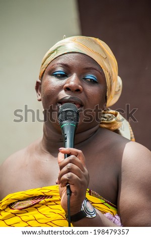 ACCRA, GHANA - MARCH 4, 2012: Unidentified Ghanaian woman sings a song at the local street music show in Ghana. Music is the main kind of entertainment in Africa