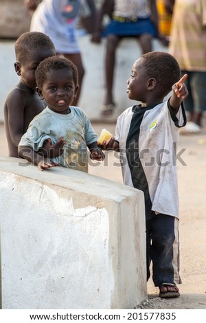 ACCRA, GHANA - MARCH 2, 2012: Unidentified Ghanaian children smile in the street in Ghana. People of Ghana suffer of poverty due to the unstable economic situation