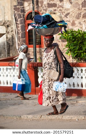 ACCRA, GHANA - MARCH 2, 2012: Unidentified Ghanaian woman carries bags on her head in Ghana. People of Ghana suffer of poverty due to the unstable economic situation