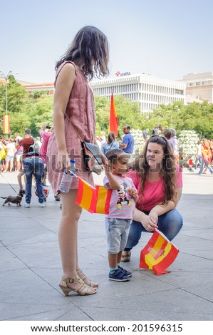 MADRID, SPAIN - JUN 19, 2014: Unidentified Spanish women with Spanish flags in the centre of Madrid on a case the celebration on a day of the inauguration of the New King of Spain Felipe IV