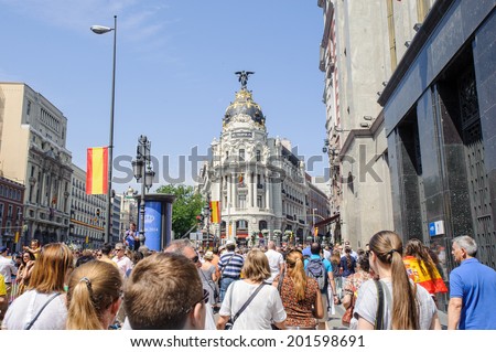 MADRID, SPAIN - JUN 19, 2014: Unidentified Spanish people with national flags walk in the centre of Madrid on a case of the celebration on a day of the inauguration of the New King of Spain Felipe IV
