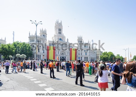MADRID, SPAIN - JUN 19, 2014: Unidentified Spanish people with national flags in the centre of Madrid on a case the celebration on a day of the inauguration of the New King of Spain Felipe IV