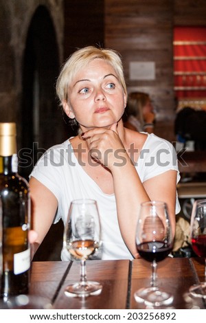 PORTO, PORTUGAL - JUN 21, 2014:  Unidentified tourist tastes the port wine of the Calem trademark. Calem company was created in 1859 and now it\'s one of the world brands of the port wines from Porto