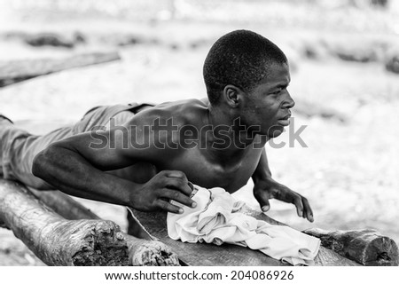 ACCARA, GHANA - MAR 6, 2012: Unidentified Ghanayan man works in the street in black and white. People of Ghana suffer of poverty due to the unstable economical situation