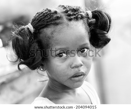 ACCARA, GHANA - MAR 2, 2012: Unidentified Ghanaian girl with pigtail in black and white. People of Ghana suffer of poverty due to the unstable economical situation