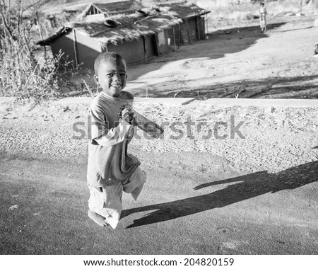 ANTANANARIVO, MADAGASCAR - JULY 3, 2011: Unidentified Madagascar boy runs happily smiling in the street. Children in Madagascar suffer of poverty due to slow development of the country