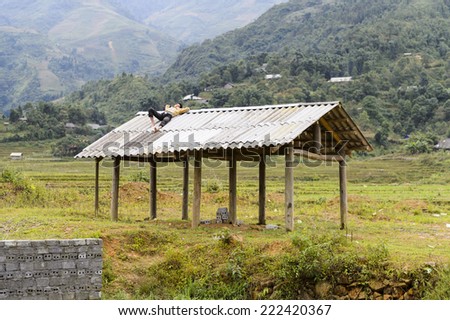 TA PHIN, LAO CAI, VIETNAM - SEP 21, 2014: Unidentified Red Dao sleeps on a roof in the Ta Phin village. Red Dao is one of the minority ethnic groups in Vietnam