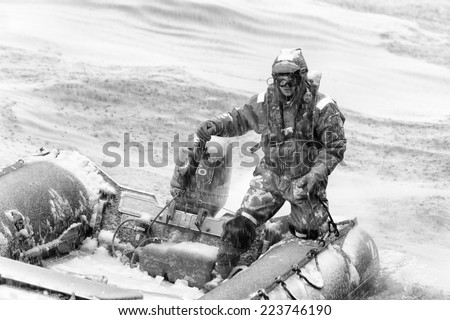 SOUTH GEORGIA, GREAT BRITAIN - NOV 9, 2012: Unidentified man in a water proof suite in a rubber boat with a motor in the Atlantic Ocean. Atlantic Ocean is the world\'s second largest ocean