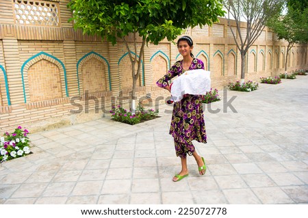 BUKHARA, UZBEKISTAN - JUNE 8, 2011: Unidentified Uzbek woman goes for a walk with her child Uzbekistan, Jun 8, 2011.  81% of people in Uzbekistan belong to Uzbek ethnic group