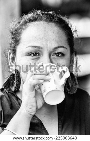 GUATEMALA CITY, GUATEMALA - JANUARY 3, 2012: Portrait of an unidentified beautiful girl having a cup of coffee in Guatemala. 59.4% of Guatemala people belong to the Mestizo ethnic group